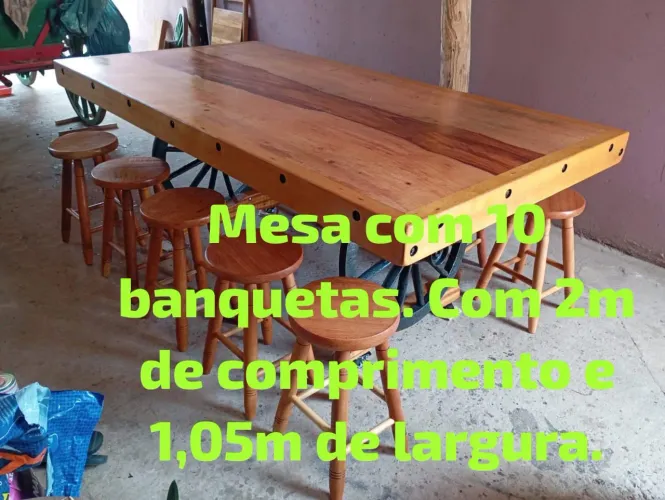 Mesa rústica com pés de rodas de carroça, acompanha 10 banquetas.