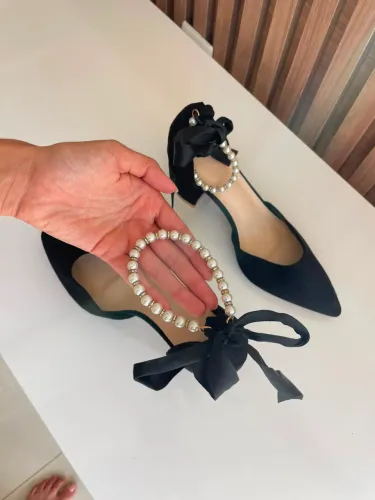 salto alto preto com detalhes em pérola