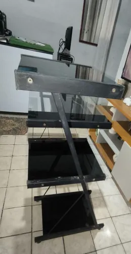 Escrivaninha de vidro com estrutura em metal. 