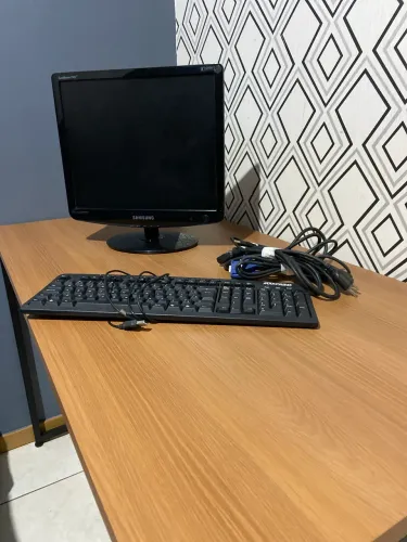 Monitor Samsung com cabos e teclado