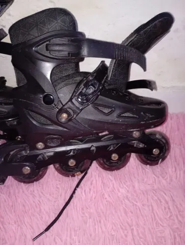 Patins  Preto  ajustável com rodas que brilhão  ao andar .