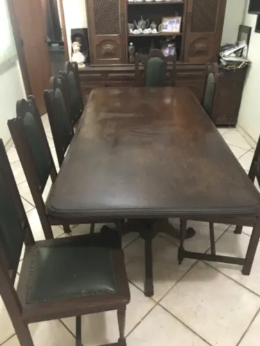Cristaleira e mesa de madeira maciça, 8 cadeiras todas com almofadas no assento e encosto.