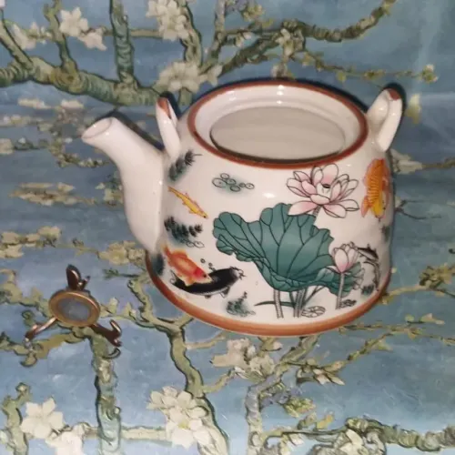 Bule de porcelana para plantas. decorada com motivos orientais e peixes.