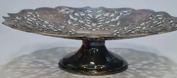 Centro de mesa ou fruteira com pedestal frequentemente feita de metal espessurado. Apresen