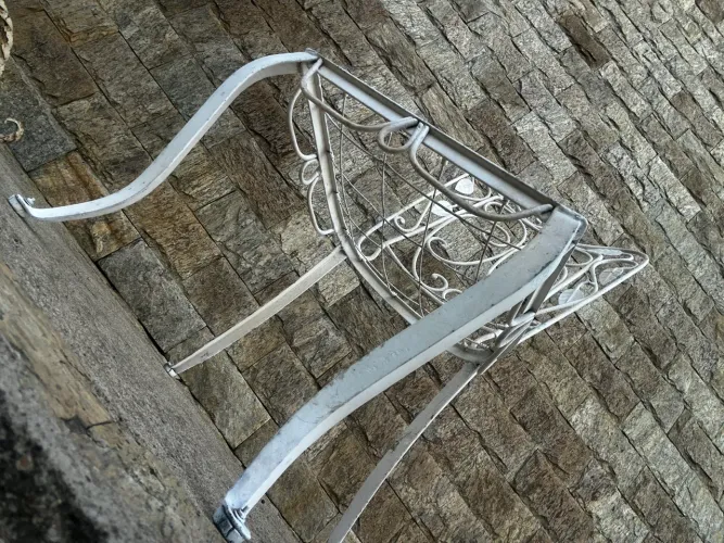 Cadeira antiga de ferro com detalhes em folhas
