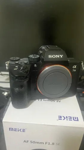 Câmera a7iii acompanhada de bateria e cage