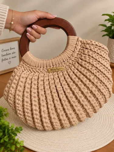 Bolsa de crochê com alça de madeira.