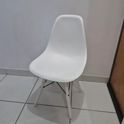 Cadeira eames com pés e assento em polipropileno. Perfil de aço estrutural. Suporta 110Kg.