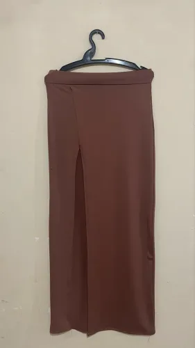 saia midi longa, em malha, na cor marrom/cappuccino, com modelagem reta e cintura alta.