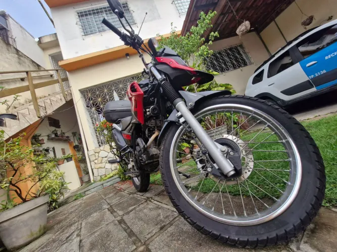 XTZ 150 Crosser S 2024 com bauleto, antena corta pipa e capacete.