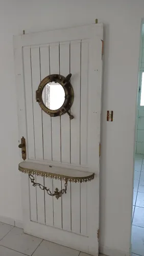 porta maciça decorada com uma escotilha de naufrágio.