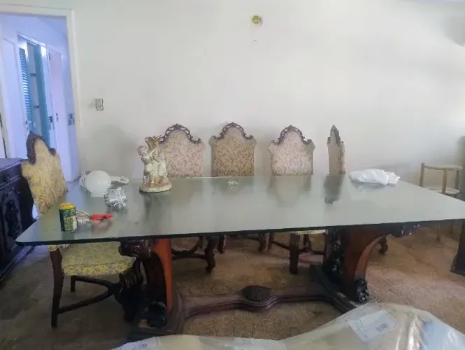 conjunto de sala de jantar com uma mesa de tampo de vidro e cadeiras de estilo barroco