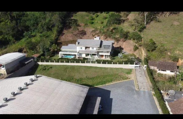 Casa a venda com galpão e um enorme terreno aos fundos.