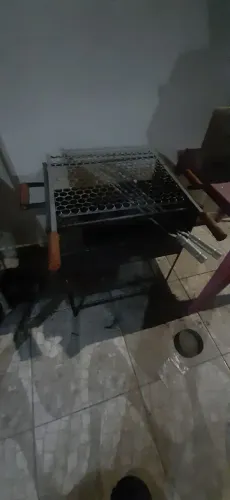 Churrasqueira preta com grelha e espetos