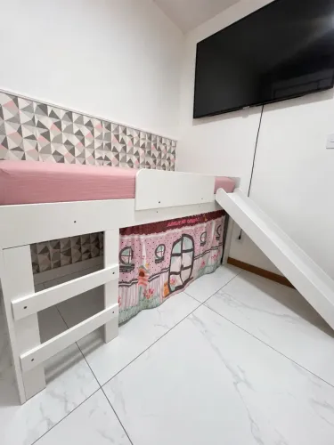 Cama infantil elevada com escorregador removível e espaço de diversão na parte inferior
