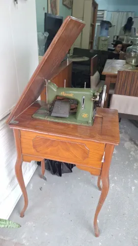 Máquina de costura com gabinete em bom estado.