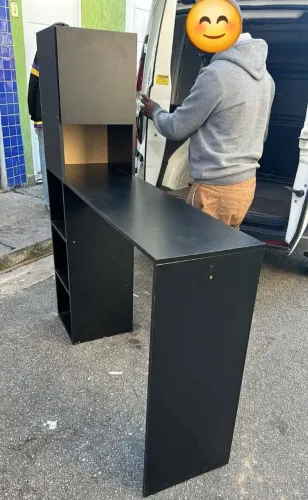 Bancada multiuso preta com armário e prateleira.