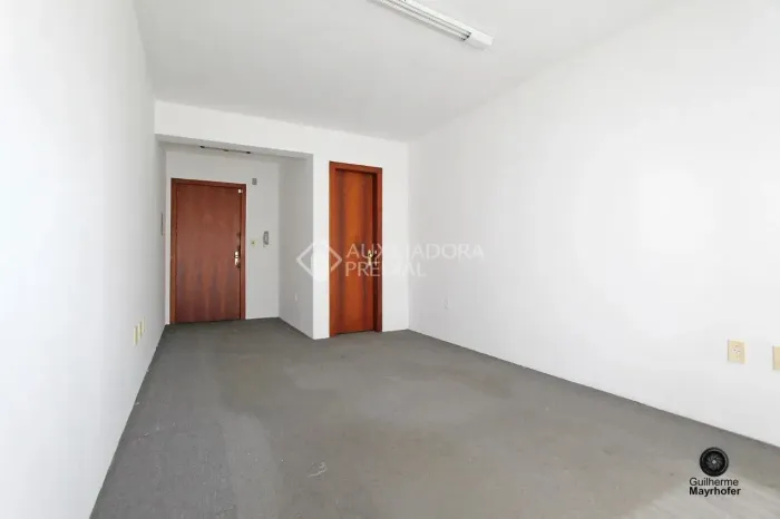 Sala comercial desocupada com 23,40 m² privativos em prédio pequeno com baixo valor condom