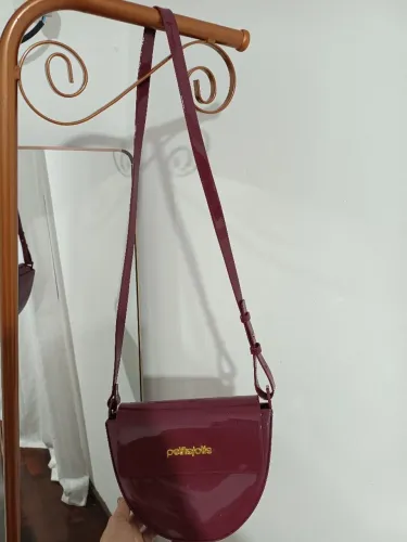 Bolsa de ombro com alça longa.