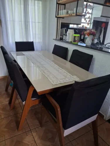 Mesa de madeira reforçada, tampo de vidro. 6 Cadeiras com braço, estofadas de pano.
