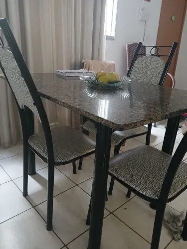 Mesa de mármore com 4 cadeiras preta.
