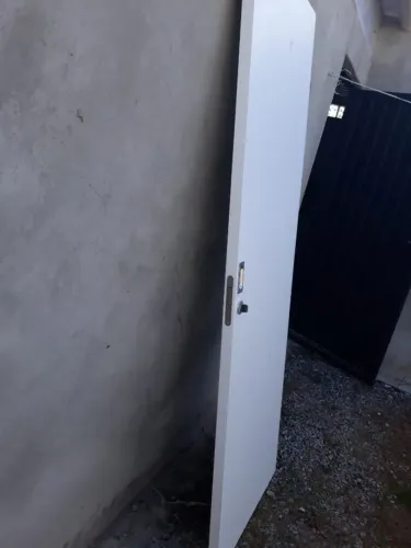 Porta de madeira nova, com acabamento branco primer liso (sem o trilho).