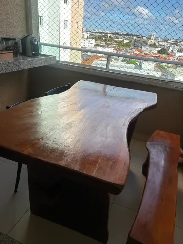 Mesa rústica de madeira acompanha o banco