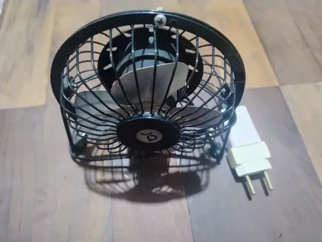 Mini ventilador de mesa portátil com estrutura em metal e alimentação USB. 