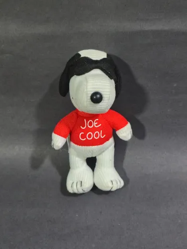 Boneco de pelúcia colecionável do personagem Snoopy em sua persona "Joe Cool". 13cm