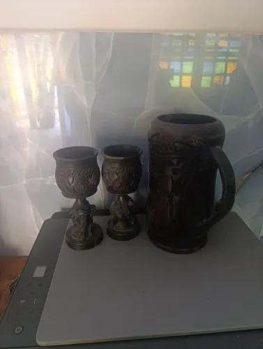 Uma jarra a base de pau preto e dois copos