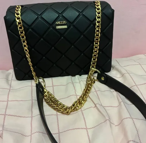 bolsa tiracolo pequena em plástico com acabamento fosco preta arezzo com alça dourada