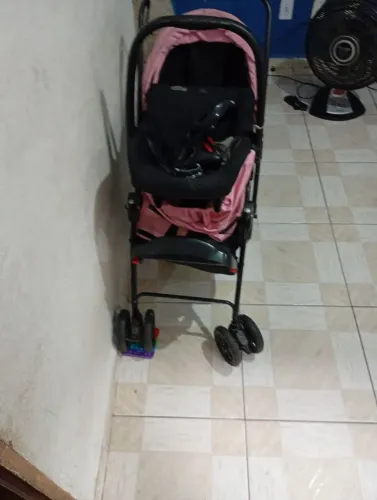 Carrinho de bebê na cor rosa com bebe comforto