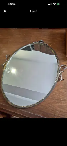 espelho oval vintage com moldura em metal dourado e detalhes ornamentais clássicos 80 X 60
