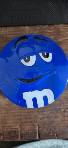 Lata redonda de colecionador do M&M's com o rosto em relevo verde amarelo e azul