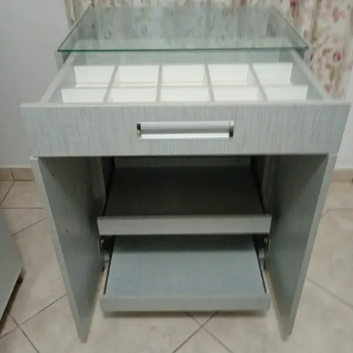 Criado mudo em madeira,tem prateleiras deslizantes e portas coisas.