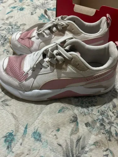 Tênis Puma feminino estilo casual/esportivo, nas cores branco com detalhes em rosa.