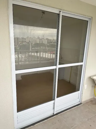 Porta Balcão de correr em alumínio branco com vidro e veneziana inferior ventilada.