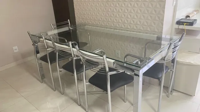 Mesa tampo de vidro, pés em inox com 6 cadeiras pés de inox e assento em courinho.