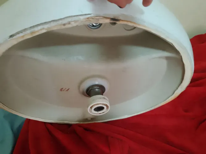Pia de banheiro de porcelana com torneira de aço inox.