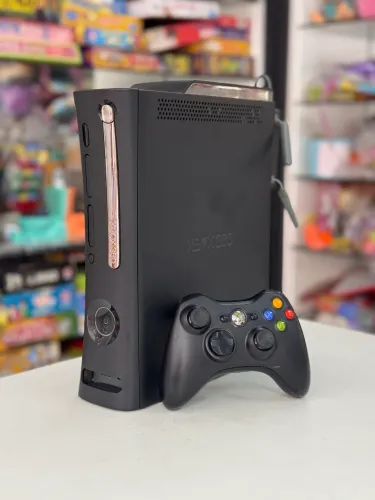 Xbox 360 Fat com um controle (com detalhe na porta de CDS)