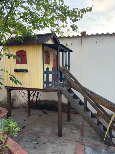 Casinha de madeira com escorregador e balanço