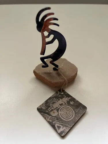 Escultura Kokopelli em metal e pedra