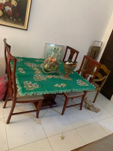 Mesa com tampo de vidro boleado com quatro cadeiras.