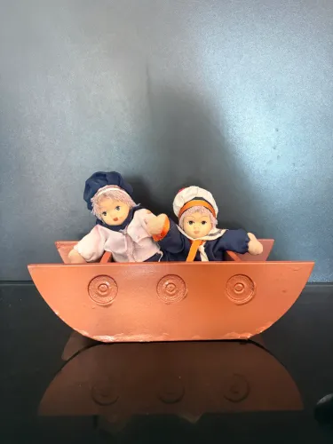 Bonecos de porcelana marinheiros no barquinho de cor cobre