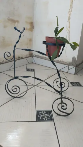 Suporte em ferro torcido pintado de preto vão com a planta