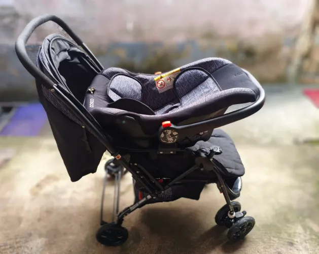 Carrinho com bebê conforto Cosco.