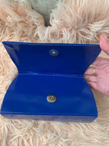 Bolsa clutch em couro envernizado azul.