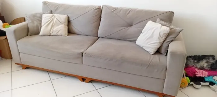 Sofá cinza claro com pés de madeira