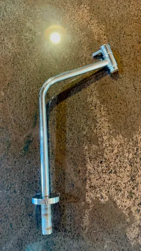 Torneira inox, lavabo e banheiro.