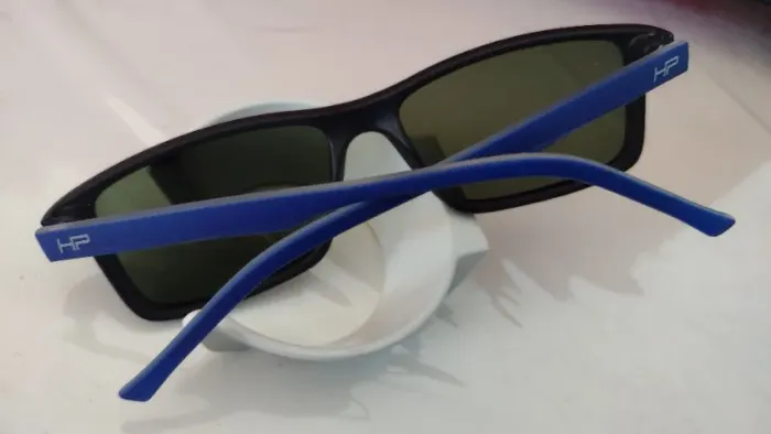 óculos solar marca HP, Frente preto fosco, haste azul fosco, lente verde clara